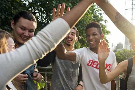 Groep jongeren die elkaar een high five geeft