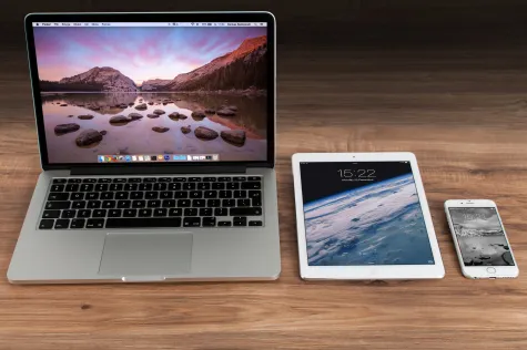 Macbook, iPad en iPhone die naast elkaar liggen